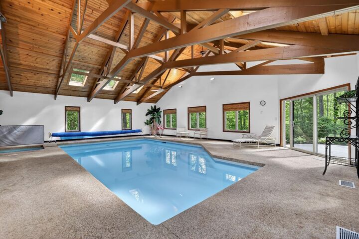 Indoor saltwater pool under a vaulted wood-beam ceiling