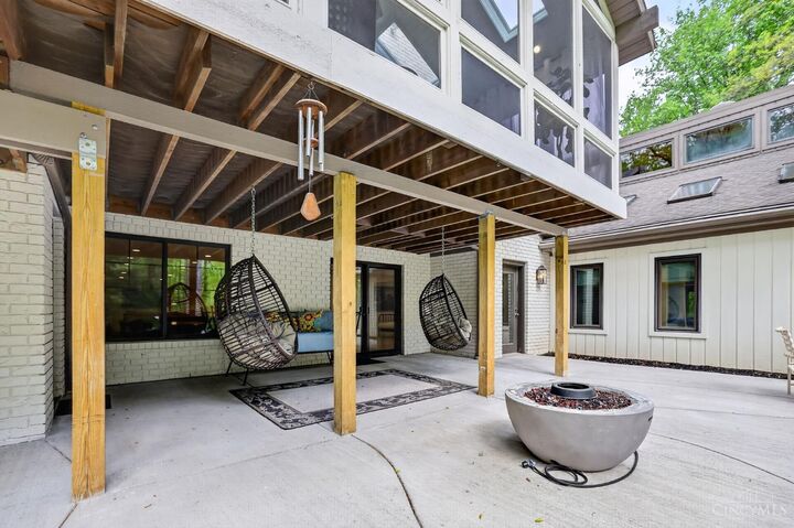 Covered patio with fire pit and hanging chairs