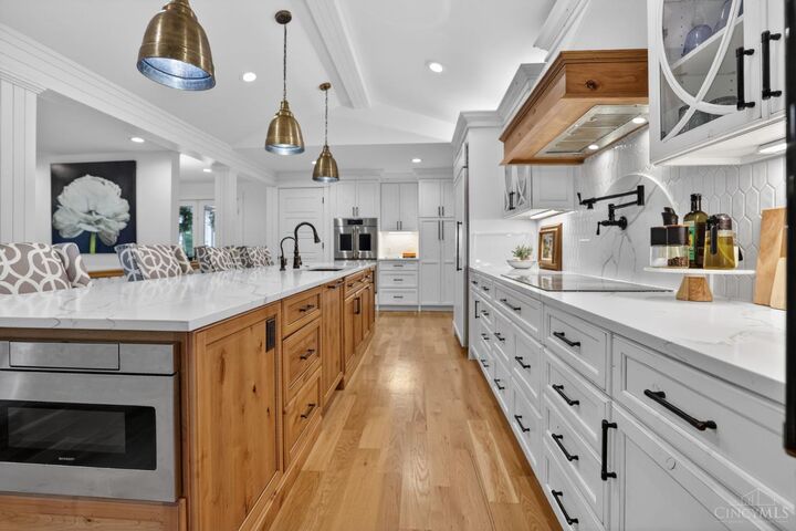 Kitchen with knotty alder island and white perimeter cabinetry
