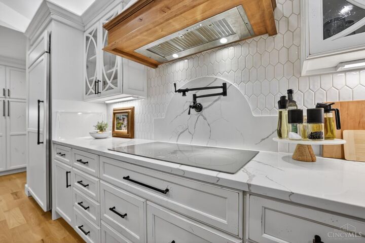 Induction cooktop with pot filler and quartz backsplash