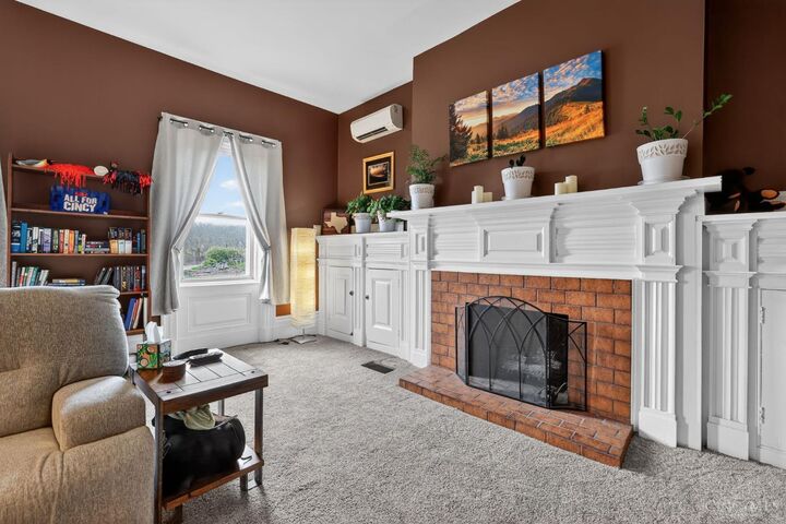 Spacious main-level living room with white fireplace mantel